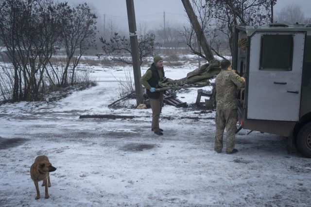 Украинские военнослужащие переносят носилки с раненым в Донецкой области