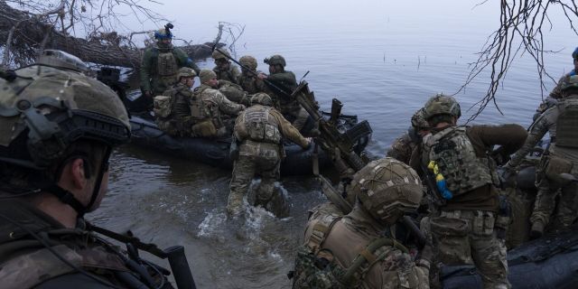 Украинские военнослужащие садятся в лодку на берегу Днепра близ Херсона, Украина