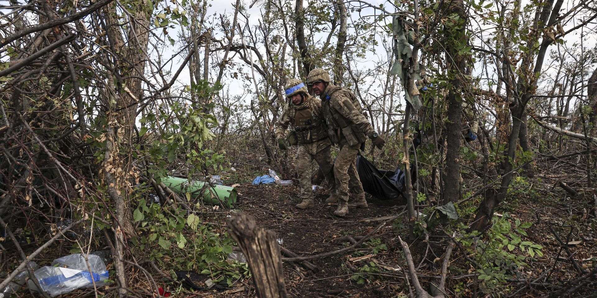 Украинские военнослужащие тащат мешки с телами убитых украинских солдат на линии фронта в нескольких километрах от Андреевки, Донецкая область