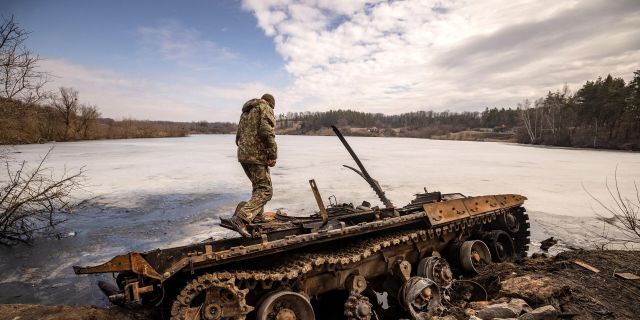 Украинский солдат осматривает уничтоженную технику. Архивная фотография