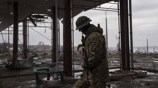 Украинский военнослужащий рядом с Антоновским мостом
