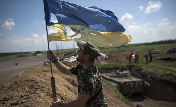 Украинский военный устанавливает флаг Украины в Марьинке недалеко от Донецка