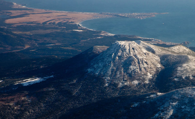 Вид на вулкан Менделеева и поселок Южно-Курильск на острове Кунашир
