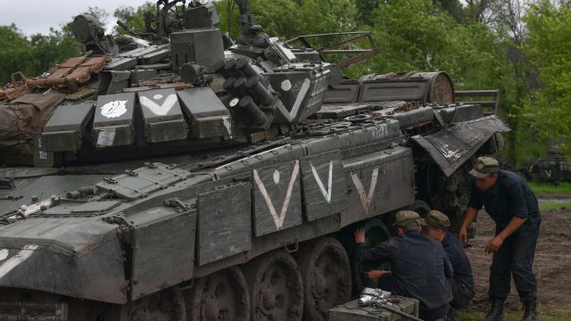 Военнослужащие ремонтной бригады Вооруженных сил РФ меняют траки танка в полевых условиях в зоне специальной военной операции на Украине