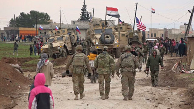 Военный конвой США и местные жители в районе города Эль-Камышлы в Сирии
