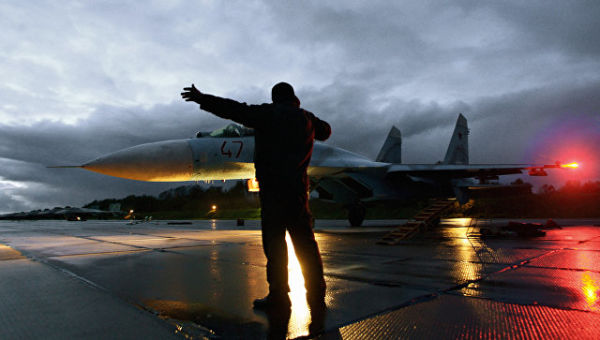 Военный техник дает отмашку на взлет истребителя Су-27. Архивное фото