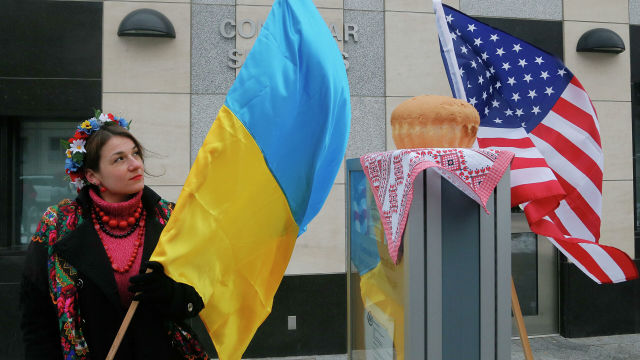 Женщина с флагом Украины у посольства США в Киеве
