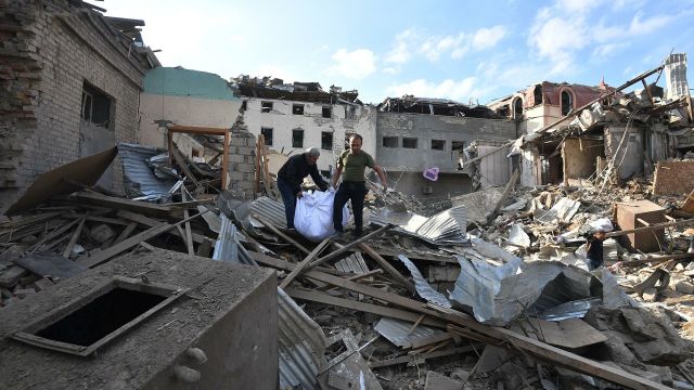 Жители собирают уцелевшие вещи на развалинах своего жилого дома, разрушенного в результате ракетного обстрела города Гянджа